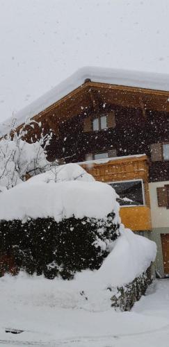 uma casa coberta de neve na frente em Ferienwohnung Juen em Sankt Gallenkirch