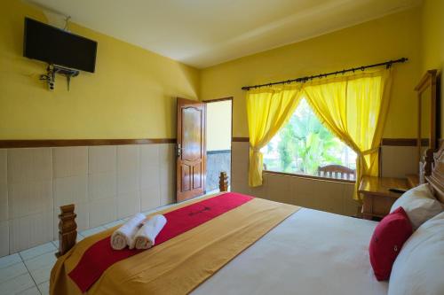 A bed or beds in a room at RedDoorz at Tanjung Alam Hotel Lovina