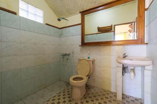 a bathroom with a toilet and a sink at RedDoorz at Tanjung Alam Hotel Lovina in Buleleng