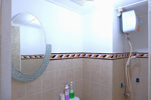 een badkamer met een douche, een spiegel en een wastafel bij 2 BR Sea View 2 Big Bed 1 Sofa bed Internet Kitchen in Jakarta