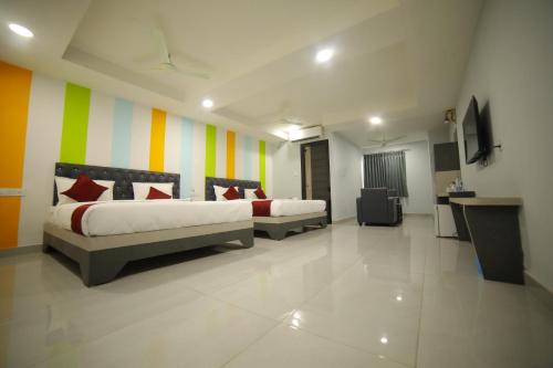 1 dormitorio con 2 camas y una pared colorida en HOTEL BLUE MOON, en Nellore