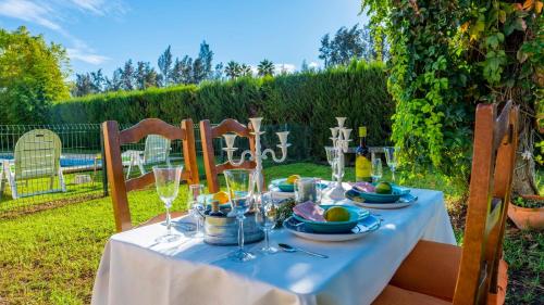 a table with a blue table cloth and wine glasses at Huerta Tío Pipa Aznalcázar by Ruralidays in Aznalcázar