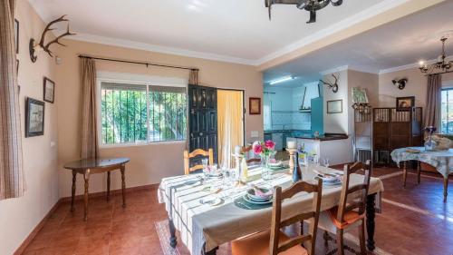 a dining room with a table and chairs and a kitchen at Huerta Tío Pipa Aznalcázar by Ruralidays in Aznalcázar
