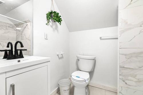 a white bathroom with a toilet and a sink at Stately Studio Apartment in Detroit