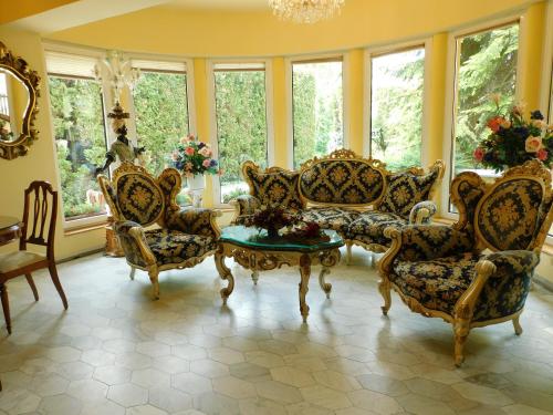 莫雄馬扎爾古堡的住宿－全景酒店，客厅配有椅子和桌子,设有窗户