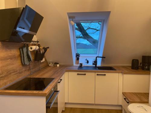 eine Küche mit einem Waschbecken und einem Fenster in der Unterkunft Meine Schule Sehlingen, stilvolle Familien-Unterkunft auf dem Land in Kirchlinteln