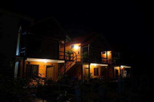 a house at night with its lights on at The PugMark Wildlife Resort in Jyoti Gaon