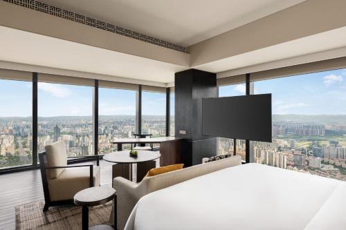 a bedroom with a bed and a view of a city at Shangri-La Nanning - The tallest hotel worldwide in Shangri-La Group in Nanning