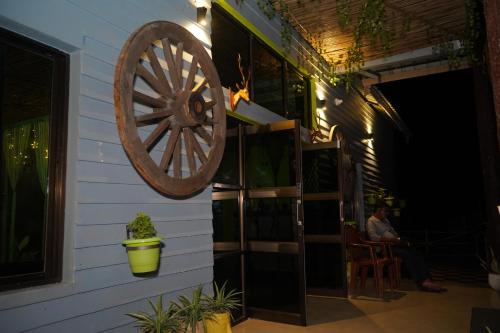 a wooden wagon wheel on the side of a house at The PugMark Wildlife Resort in Jyoti Gaon
