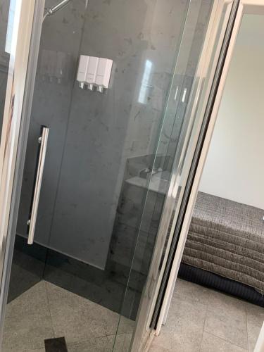 a glass shower door in a room at Y Motels Kingaroy in Kingaroy