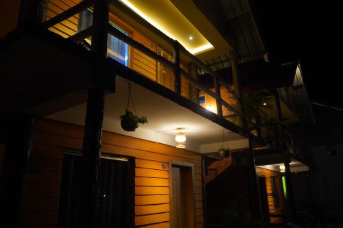 a house at night with a balcony and lights at The PugMark Wildlife Resort in Jyoti Gaon