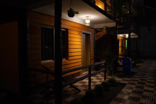 a house at night with a bench in front of it at The PugMark Wildlife Resort in Jyoti Gaon