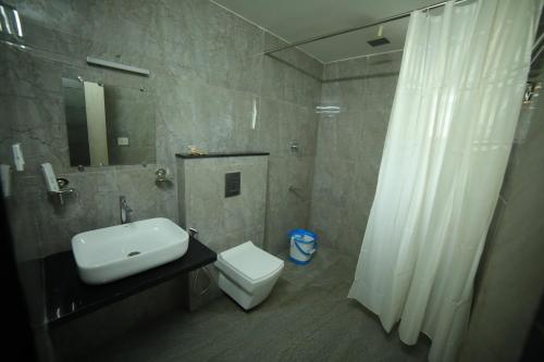 y baño con lavabo, aseo y ducha. en HOTEL BLUE MOON, en Nellore