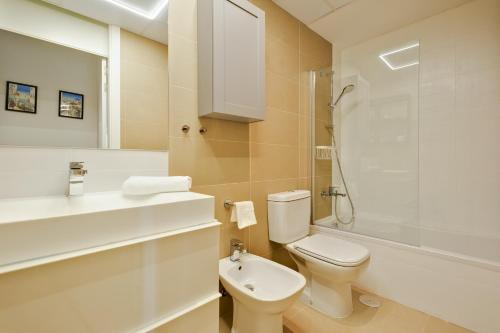 La salle de bains est pourvue de toilettes, d'un lavabo et d'une douche. dans l'établissement Intempo Gold&Gris Apartment, à Benidorm