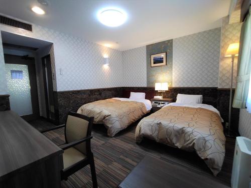 Un pat sau paturi într-o cameră la Kitami Towa Hotel
