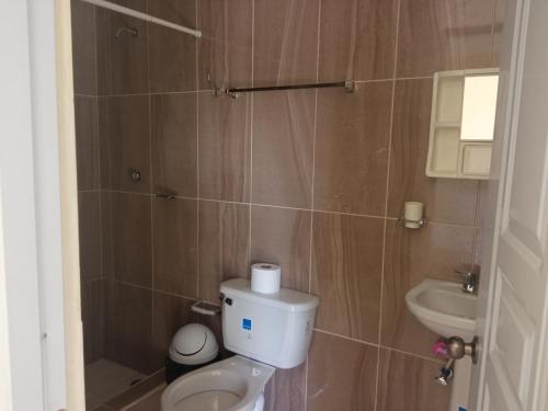 uma casa de banho com um WC e um lavatório em Salemar Hostal - Cerca de la playa em Sosúa