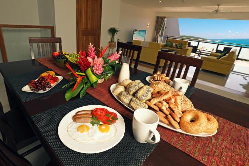 a table with plates of breakfast food on it at Cliffhanger Mountain Villas with Private Pools in Misere