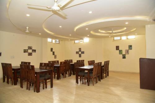 une salle à manger avec des tables et des chaises en bois et un plafond dans l'établissement THE TRINETRA VILLA, à Sawai Madhopur