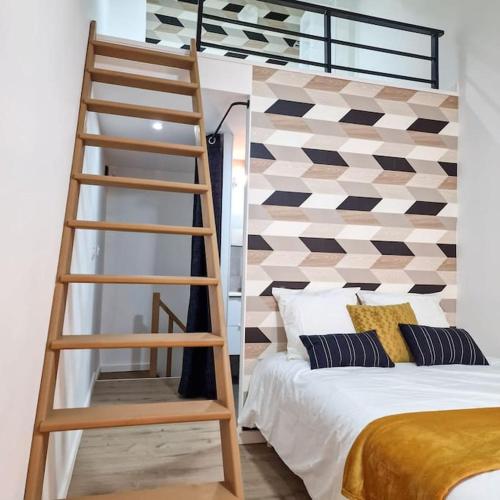 - une chambre avec une échelle à côté d'un lit dans l'établissement L’atelier A magnifique Loft avec terrasse privée, à Saint-Étienne