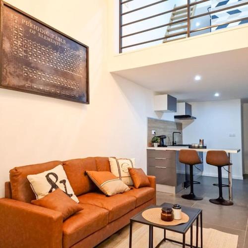 un salon avec un canapé et une table dans l'établissement L’atelier A magnifique Loft avec terrasse privée, à Saint-Étienne