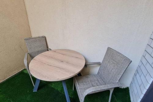 a wooden table and two chairs sitting next to a table at Adorable Basement Apartment in a Kibbutz in Gan Shelomo