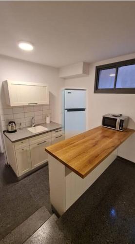 a kitchen with a wooden counter top and a refrigerator at Adorable Basement Apartment in a Kibbutz in Gan Shelomo