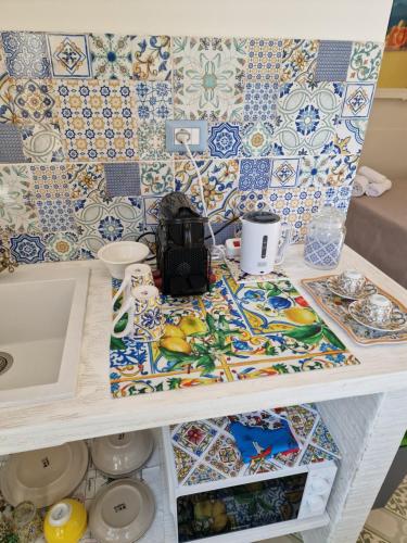 a kitchen counter with colorful tiles on the wall at Althea Etna Garden in Nicolosi