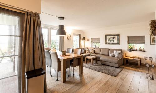 a living room with a table and a couch at Hof van Salland Hellendoorn in Hellendoorn