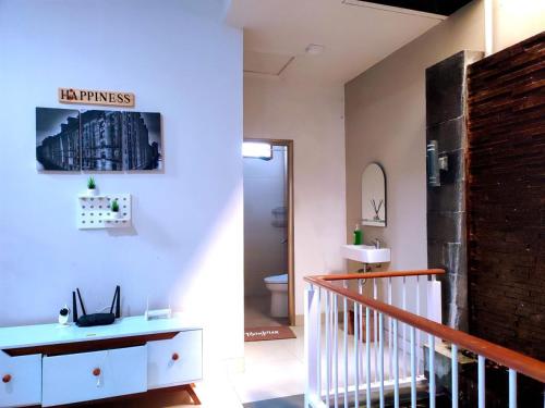 a hallway with a staircase and a bathroom with a toilet at Papringan Suite House in Demangan