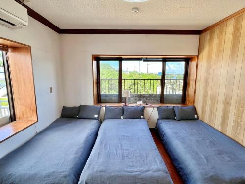 A bed or beds in a room at バーベキューもできる! 海と浜比嘉大橋を一望できる宿