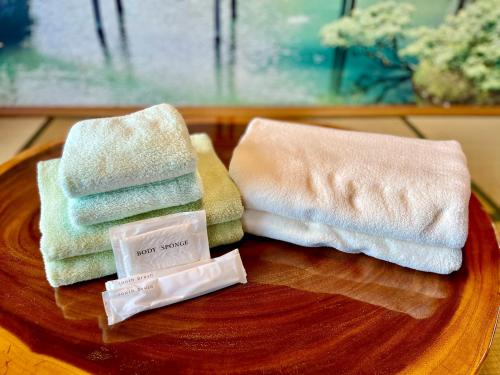 dwa ręczniki na drewnianym talerzu w obiekcie バーベキューもできる! 海と浜比嘉大橋を一望できる宿 w mieście Henza