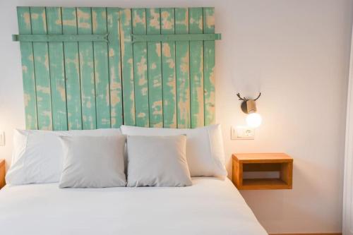 a bed with white pillows and a green headboard at Envalira Vacances - Menta in Pas de la Casa