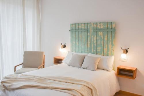 a bedroom with a white bed and a chair at Envalira Vacances - Menta in Pas de la Casa