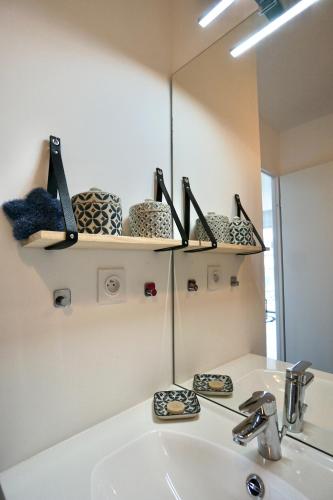 une salle de bain avec un lavabo et un miroir dans l'établissement Rêve salé, à Concarneau