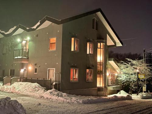 Una casa en la nieve por la noche en Pension Puutaro en Zao Onsen