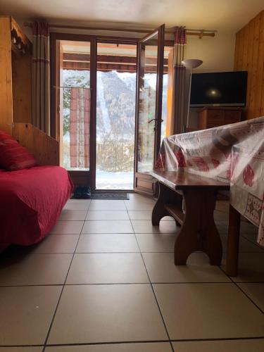 um quarto com uma cama e uma mesa num piso de azulejo em Chalets La Caillaude em La Salle Les Alpes