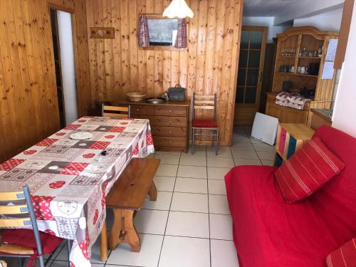 uma sala de jantar com uma mesa e um sofá vermelho em Chalets La Caillaude em La Salle Les Alpes