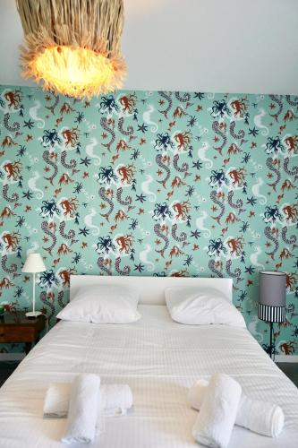 une chambre avec un lit avec un papier peint fleuri dans l'établissement Rêve salé, à Concarneau