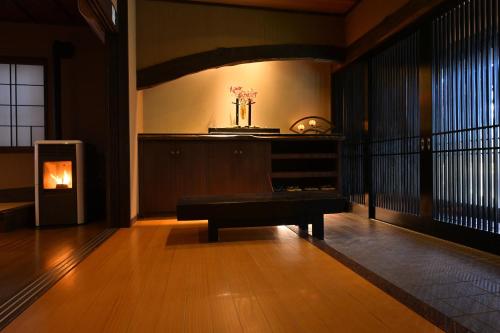 a living room with a table and a fireplace at Akari no Yado Okabe in Shibukawa