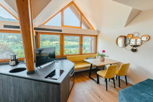 a kitchen and living room with a table and chairs at Ferienhaus Holzer in Weissensee