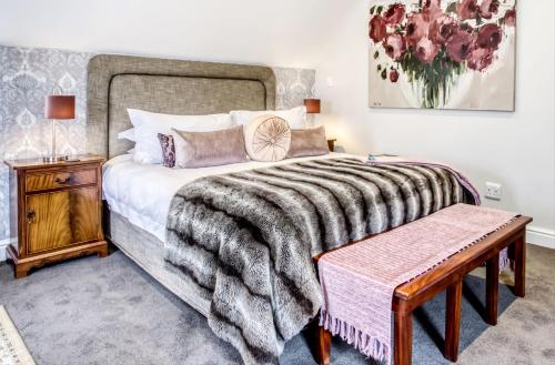 a bedroom with a large bed and a wooden table at Vredenburg Manor House in Somerset West