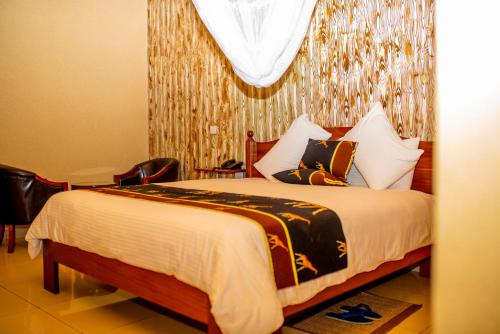 a bedroom with a bed and a chandelier at The Garden Place Hotel in Ruhengeri