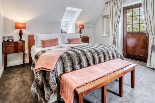 a bedroom with a large bed and a wooden table at Vredenburg Manor House in Somerset West