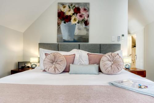 a bedroom with a bed with pink and white pillows at Vredenburg Manor House in Somerset West