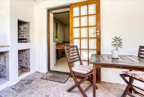 a room with a table and chairs and a window at Vredenburg Manor House in Somerset West