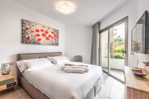 a white bedroom with a large bed and a desk at Jardines - Tabor 0-2 POOL VIEW & GARDEN 1B in Palm-mar