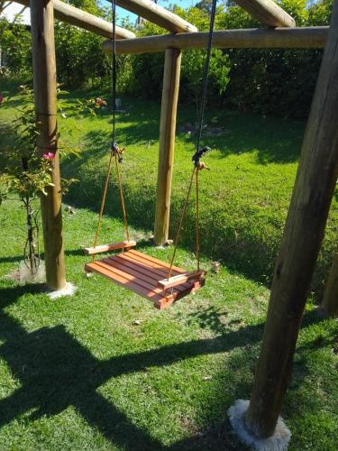 a swing in the grass in a park at Casa de campo Rosa dos ventos in Rodeio