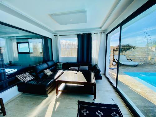 a living room with a couch and a table at LES OLIVIERS Villa N2 avec piscine privée in Oualidia