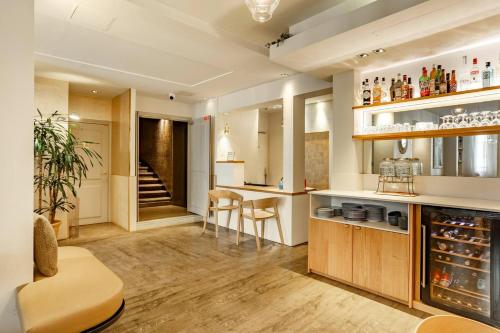 a kitchen with a bar with stools and a table at Hotel Opéra Marigny in Paris