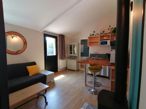 a living room with a couch and a kitchen at Les Callunes chambres d'hôtes et gîte pour 2 Bassin d'Arcachon in Lanton